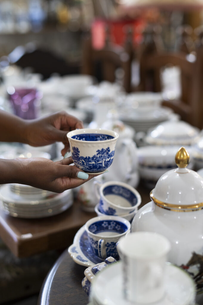 side view hands holding cup antique store